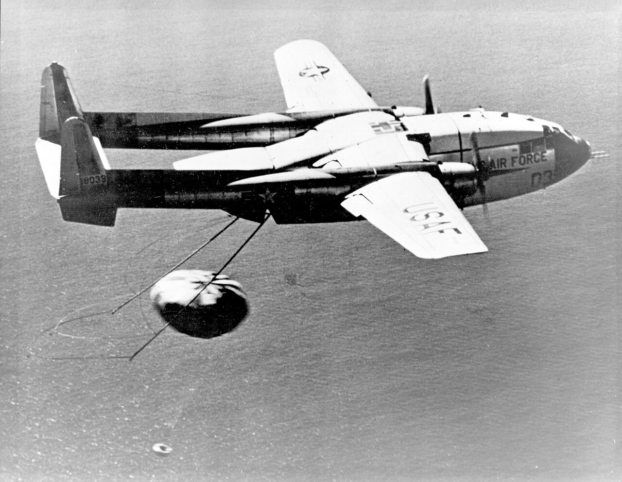 A U.S. Air Force C-119J 'Flying Boxcar' snags a parachute-borne CORONA film-return capsule in mid-air, 1960.
