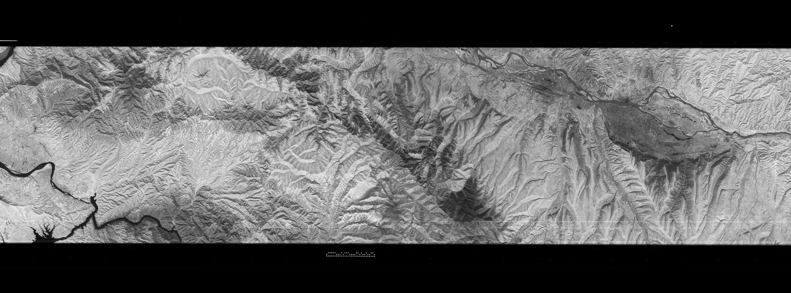A wide CORONA Keyhole satellite strip showing the mountainous terrain and river valleys around Lanzhou, China, in the early 1960s.